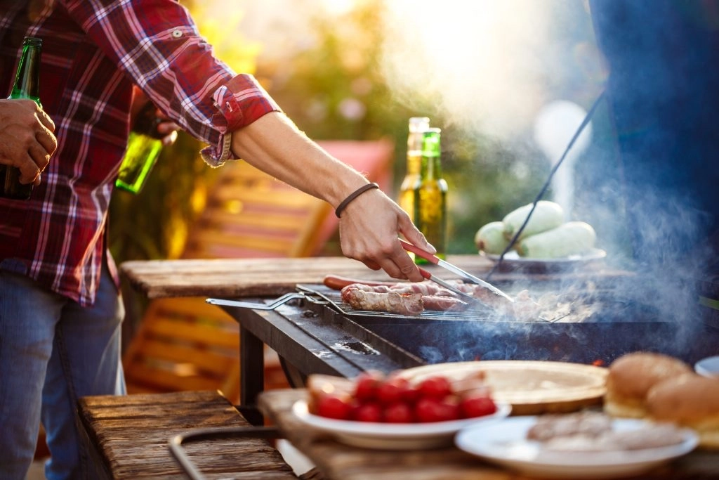 young men roasting barbecue grill cottage countryside 1024x683 1