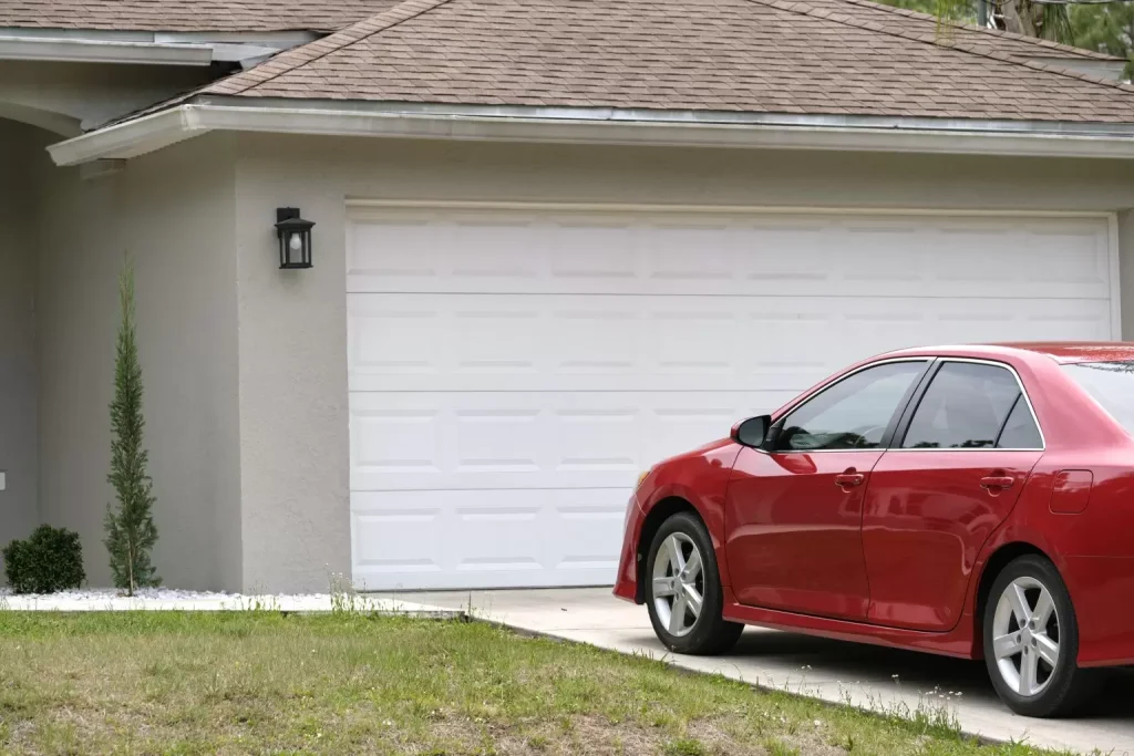 car parked front wide garage double door concrete driveway